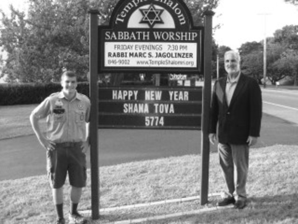 Benjamin Amundson, left, and Rabbi Marc Jagolinzer, rabbi of Temple Shalom, stand before new signage in Middletown. /AMUNDSON FAMILY